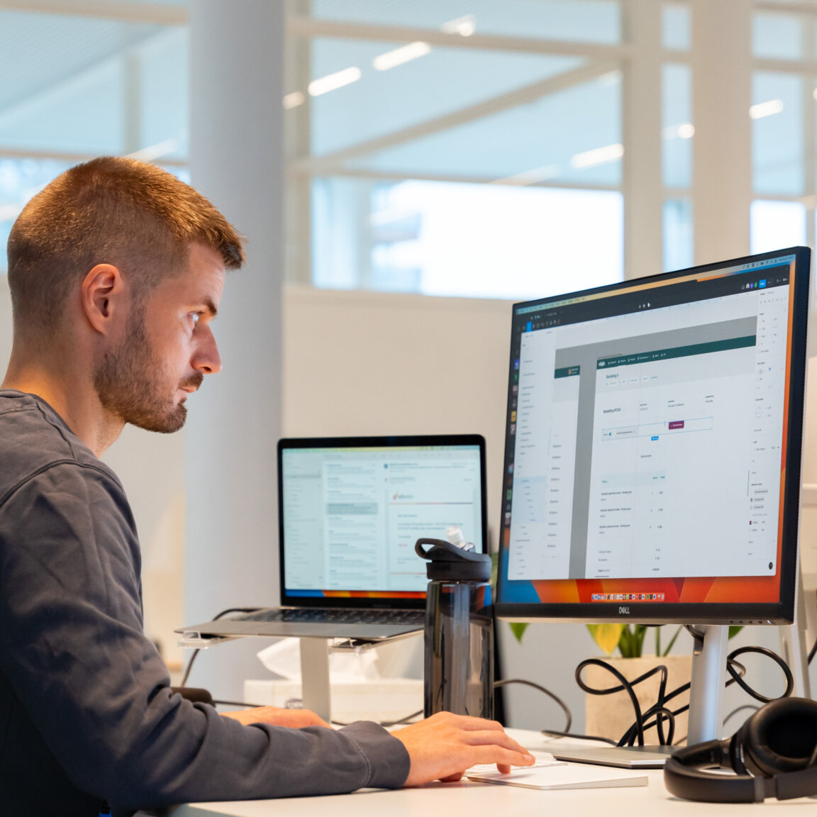 Een UX-expert analyseert de toegankelijkheid van een digitaal interface op een groot computerscherm in een heldere kantooromgeving.