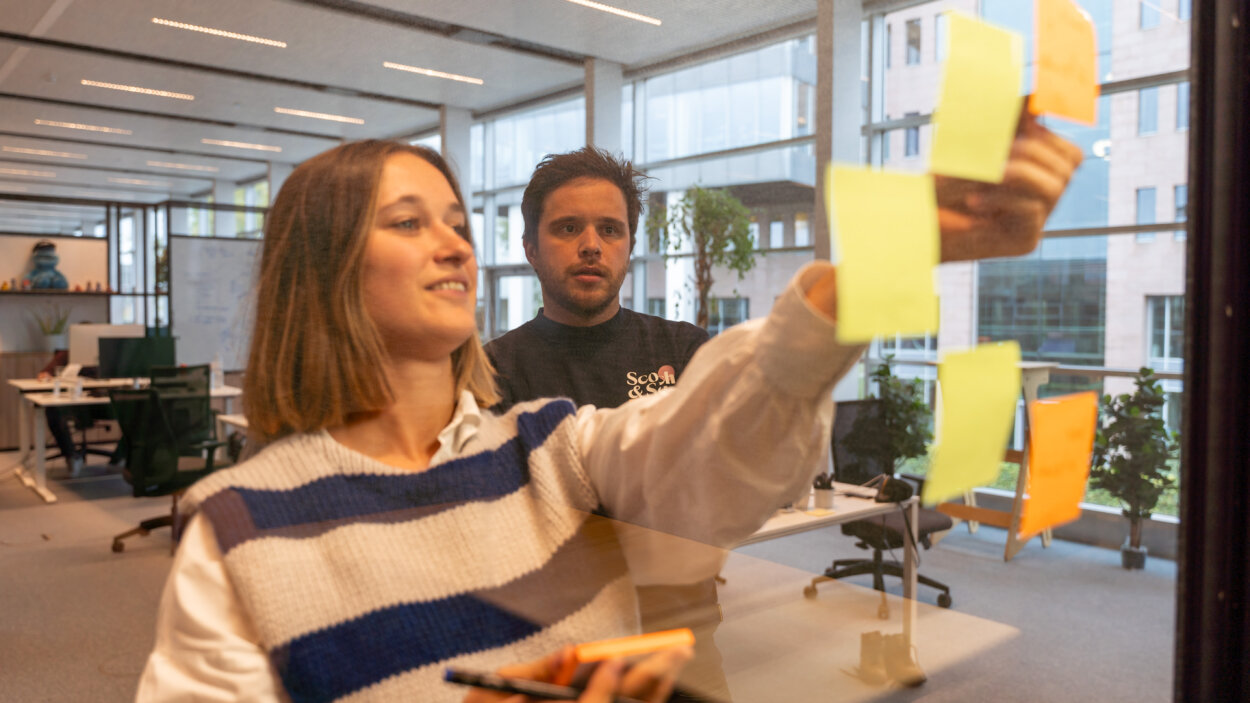 2 personen die met post-its de concurrentie vergelijken